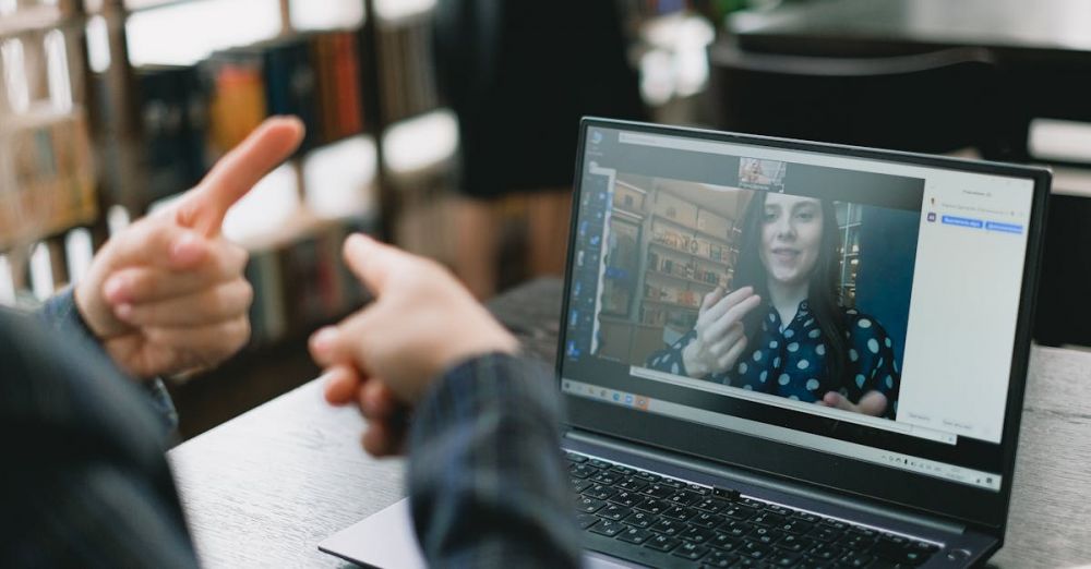 Maori Language - Young lady learning sign language during online lesson with female tutor