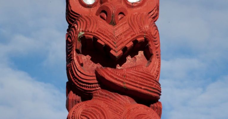 Maori Sites - Red Maori Totem Pole against Blue Sky