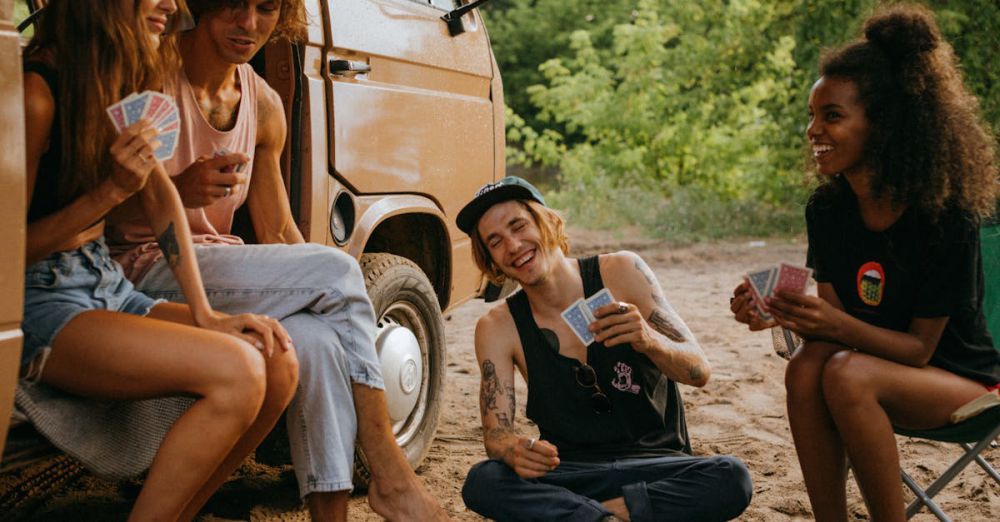 Beach Camping - Friends Playing a Card Game outside Their Camper Van