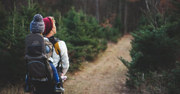 Family Camping - Shallow Focus on Blond Haired Woman in White Long Sleeve Shirt Carrying a Baby on Her Back