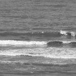 Surfing Beaches - A black and white photo of a surfer on the beach