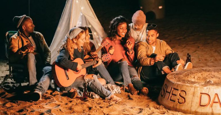Beach Bonfires - Group of Friends Sitting on Beach Sand
