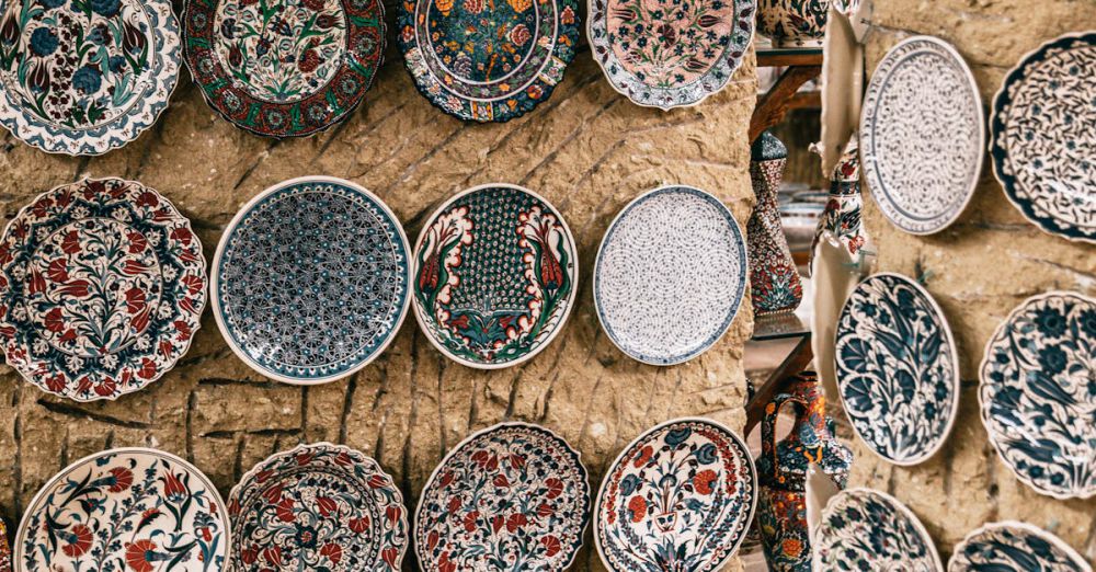 Local Dishes - Many oriental plates with different ornaments decorating rough stone walls in daytime in Morocco