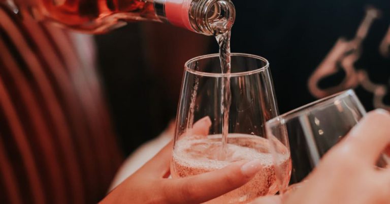 Wine Festivals - Crop anonymous woman pouring sparkling wine from bottle into glass of female friend during bridal shower party