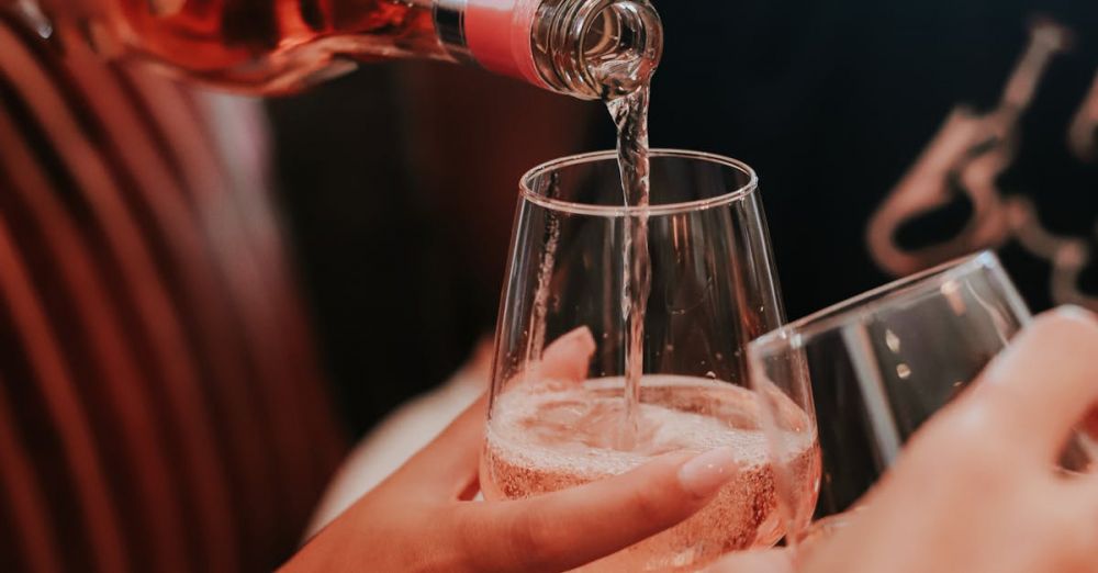 Wine Festivals - Crop anonymous woman pouring sparkling wine from bottle into glass of female friend during bridal shower party